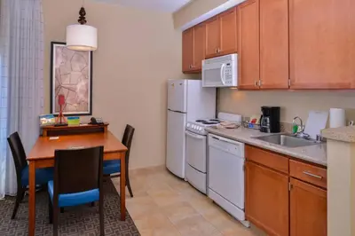 a small kitchen with a table and a kitchen with a refrigerator at TownePlace Suites by Marriott Thousand Oaks Ventura County in Thousand Oaks