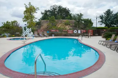 a large blue swimming pool with chairs and tables at TownePlace Suites by Marriott Thousand Oaks Ventura County in Thousand Oaks