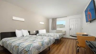 a hotel room with two beds and a table at Motel 6 Ontario, CA - Airport in Ontario