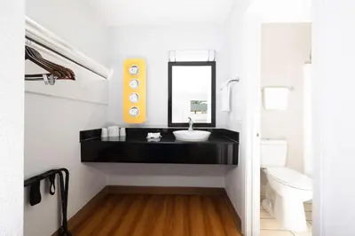 a black bathroom with a sink and a mirror at Motel 6 Ontario, CA - Airport in Ontario