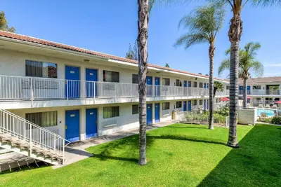an exterior view of a building with palm trees at Motel 6-Rowland Heights, CA - Los Angeles - Pomona in Rowland Heights