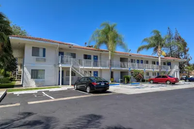 a hotel with cars parked in a parking lot at Motel 6-Rowland Heights, CA - Los Angeles - Pomona in Rowland Heights