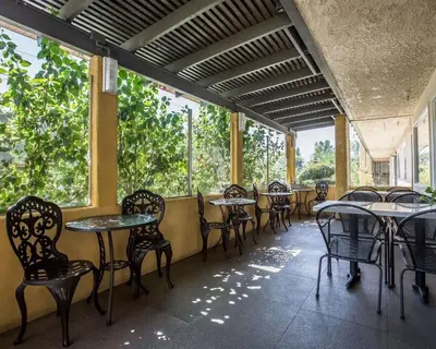 an empty restaurant with tables and chairs and windows at Quality Inn Ontario Airport Convention Center in Ontario