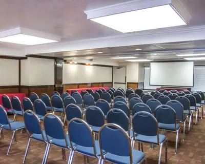 a conference room with blue chairs and a white screen at Quality Inn Riverside near UCR and Downtown in Riverside