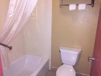 a bathroom with a white toilet and a bath tub at Thunderbird Lodge in Riverside