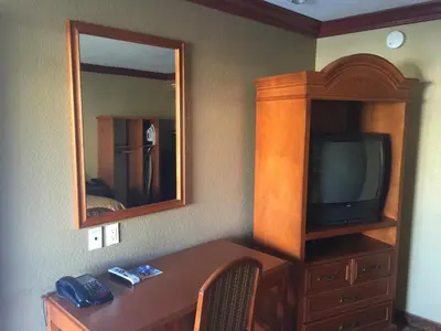 a room with a table with a tv and a mirror at Thunderbird Lodge in Riverside