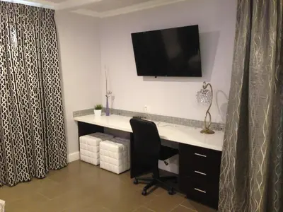 a office with a desk with a chair and a television on the wall at Hollywood VIP Hotel in Los Angeles