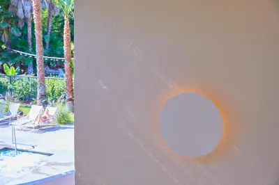 a round light on a wall next to a yard at The Capri Hotel in Ojai