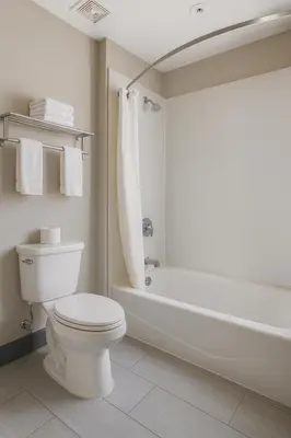 a white bathroom with a toilet and a bath tub at Motel 6-Westminster, CA - North in Westminster