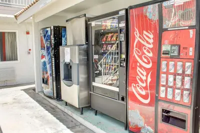 two cocacola machines are lined up in a store at Motel 6-Lancaster, CA in Lancaster