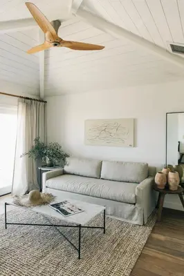 a living room with a couch and a ceiling fan at The Surfrider Malibu in Malibu