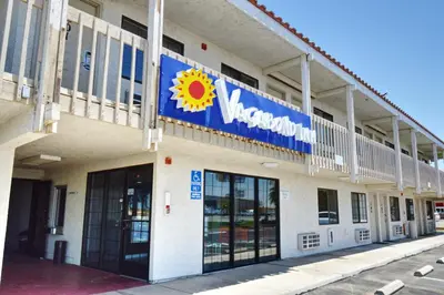 a building with a sun sign on the side of it at Vagabond Inn Buttonwillow North I-5 in Buttonwillow