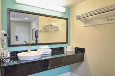 a bathroom with a sink and a large mirror at Vagabond Inn Buttonwillow North I-5 in Buttonwillow