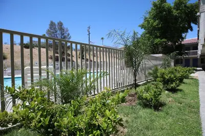 a fence in front of a yard with plants at Motel 6-Barstow, CA in Barstow