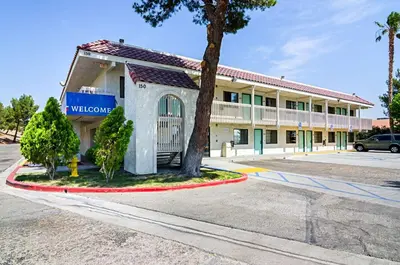 a building with a tree in front of it at Motel 6-Barstow, CA in Barstow