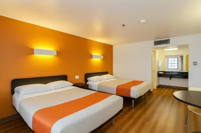 a hotel room with two beds and a table at Motel 6-Thousand Oaks, CA in Thousand Oaks