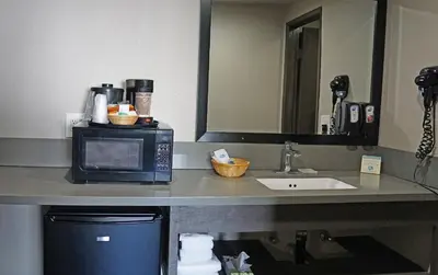 a counter with a microwave and a sink in a hotel room at Hawthorne Plaza Inn Near LAX in Hawthorne