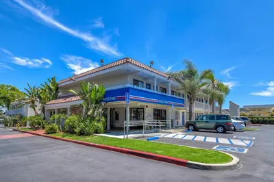 a building with a car parked in a parking lot at Motel 6-Pomona, CA - Los Angeles in Pomona
