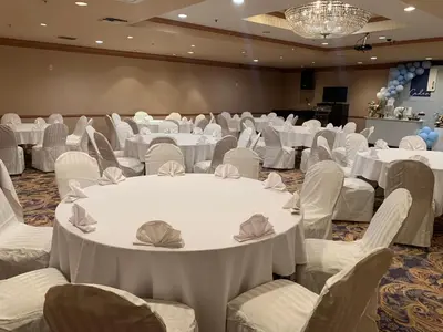a banquet hall with white tables and chairs at Oxford Palace Hotel in Los Angeles