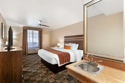 a hotel room with a bed and a sink at Best Western Plus Country Park Hotel in Tehachapi