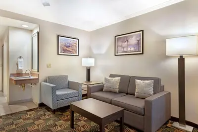 a living room with a couch and a chair at Best Western Plus Country Park Hotel in Tehachapi