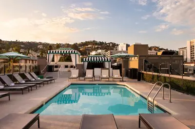 a pool on the roof of a building with lounge chairs at Chamberlain West Hollywood in Los Angeles