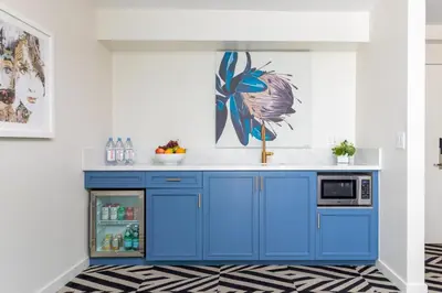 a kitchen with blue cabinets and a refrigerator at Chamberlain West Hollywood in Los Angeles