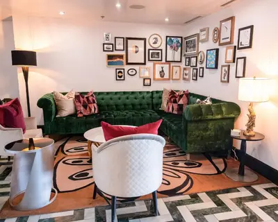 a living room with a green couch and a table at Chamberlain West Hollywood in Los Angeles