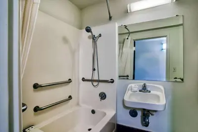 a bathroom with a sink and a tub and a mirror at Motel 6-Hesperia, CA - West Main Street I-15 in Hesperia