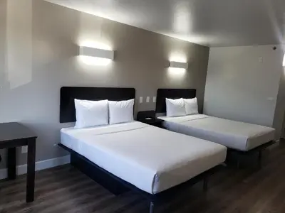 two beds in a room with white sheets at Motel 6-Hesperia, CA - West Main Street I-15 in Hesperia