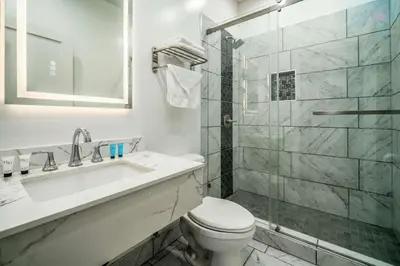 a bathroom with a toilet and a sink and a shower at Rodeway Inn & Suites Pasadena in Pasadena