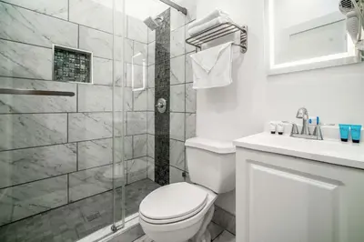 a white bathroom with a toilet and a shower at Rodeway Inn & Suites Pasadena in Pasadena
