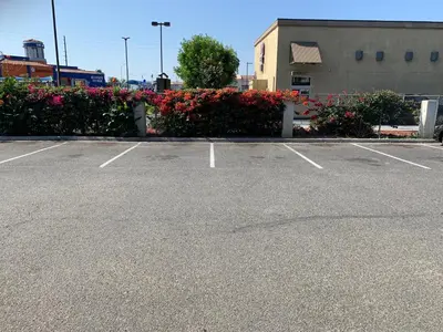 a parking lot with flowers in front of a building at Morada Inn in Anaheim