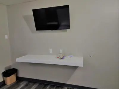 a tv on a wall with a white shelf at Morada Inn in Anaheim
