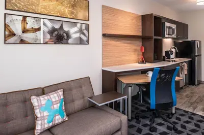 a living room with a couch and a table and a kitchen at TownePlace Suites by Marriott San Bernardino Loma Linda in Loma Linda