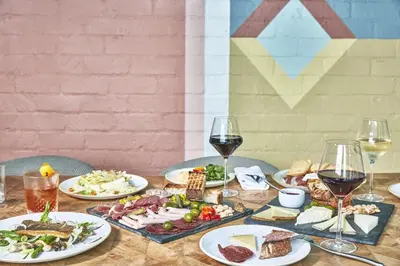 a table with plates of food and glasses of wine at Avalon Hotel Beverly Hills, a Member of Design Hotels in Los Angeles