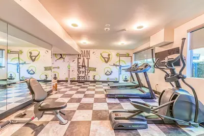 a gym with cardio equipment and a checkerboard floor at Lexen Hotel - North Hollywood Near Universal Studios in North Hollywood