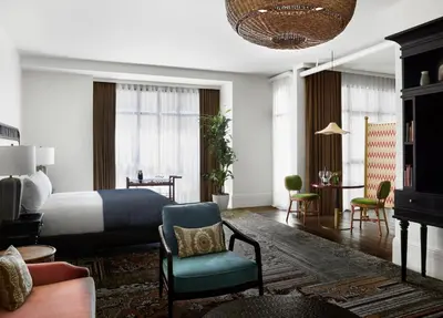 a bedroom with a bed and a couch and a chair at The Aster in Los Angeles