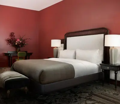 a bedroom with a large bed with red walls at The Aster in Los Angeles
