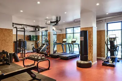 a gym with treadmills and machines in a room at The Aster in Los Angeles