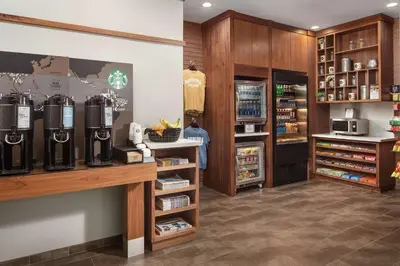 a coffee shop with a drink dispenser and a refrigerator at DoubleTree by Hilton Claremont in Claremont