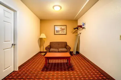 a living room with a chair and a table at Regency Inn & Suites Downey in Downey