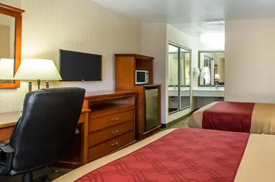 a hotel room with a bed and a desk with a computer at Econo Lodge Inn & Suites Riverside - Corona in Riverside