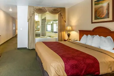 a hotel room with a large bed and a bathroom at Econo Lodge Inn & Suites Riverside - Corona in Riverside