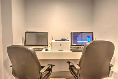 two computers sitting on a desk with two chairs at Best Western Plus Media Center Inn & Suites in Burbank