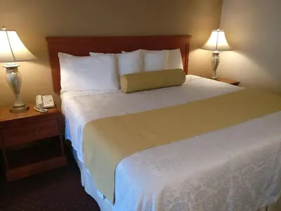 a bedroom with a bed with two lamps and a phone at Burbank Inn and Suites in Burbank