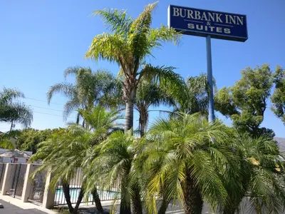 a street sign with palm trees in front of a building at Burbank Inn and Suites in Burbank
