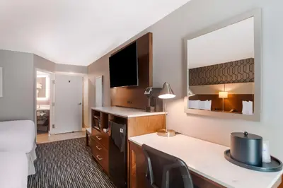a hotel room with a desk and a large mirror at Best Western Plus Commerce Hotel in Los Angeles