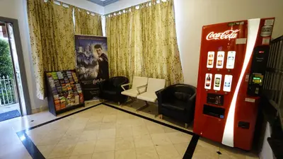 a coca cola machine and chairs in a room at Trylon Hotel - Hollywood in Los Angeles