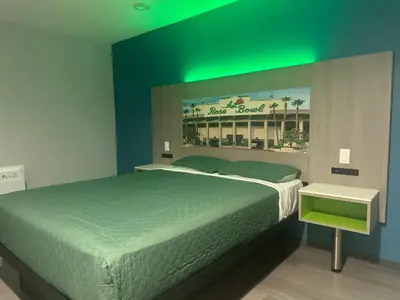 a bedroom with a large bed with a green ceiling at Hi-Way Host Motel in Pasadena